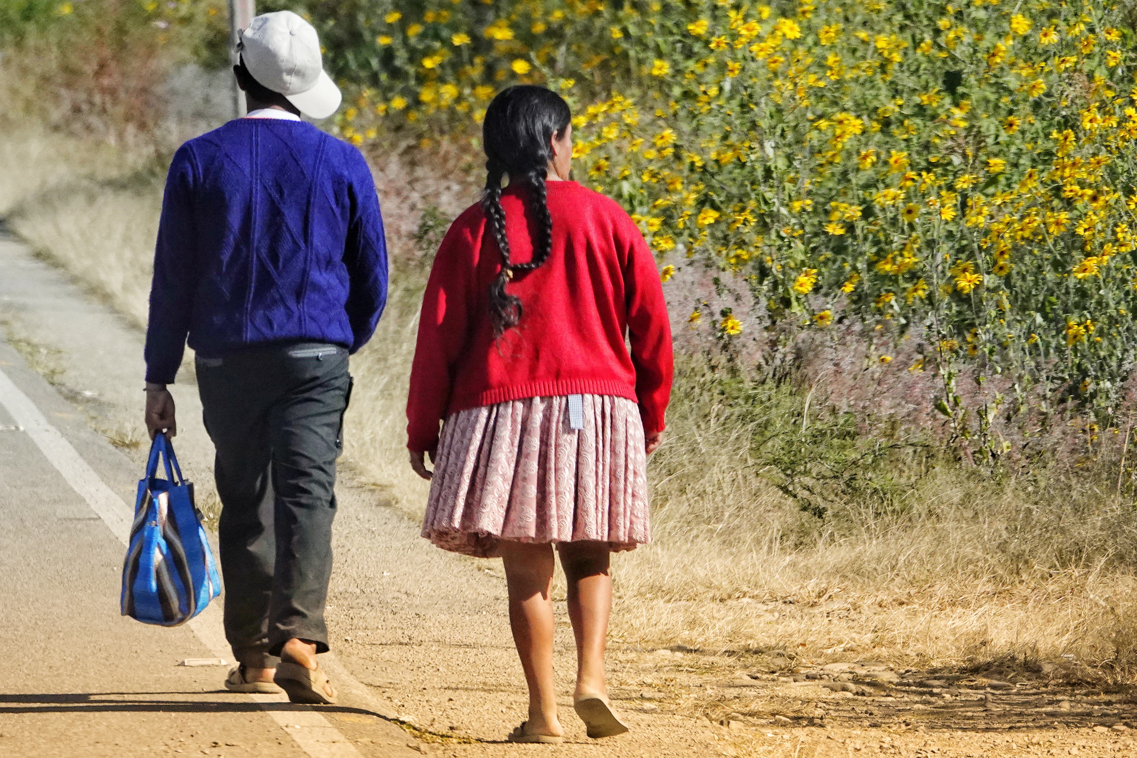 Deux personnes marchant sur une route bolivienne